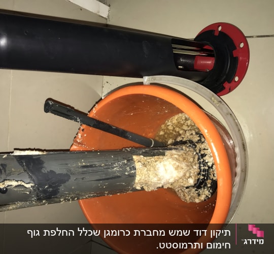 חלקי דוד שמש עם אבנית בתוך דלי כתום